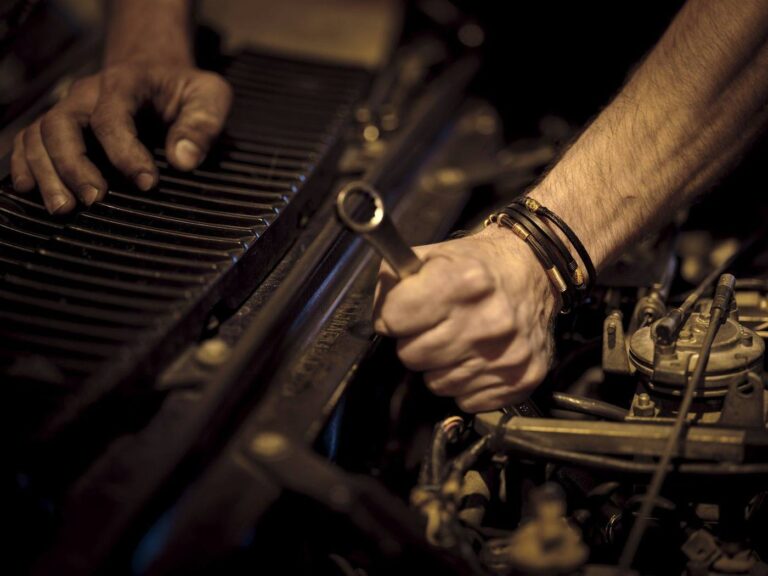 Mechanic servicing a diesel engine with a wrench